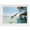 a man diving into the ocean from a dock