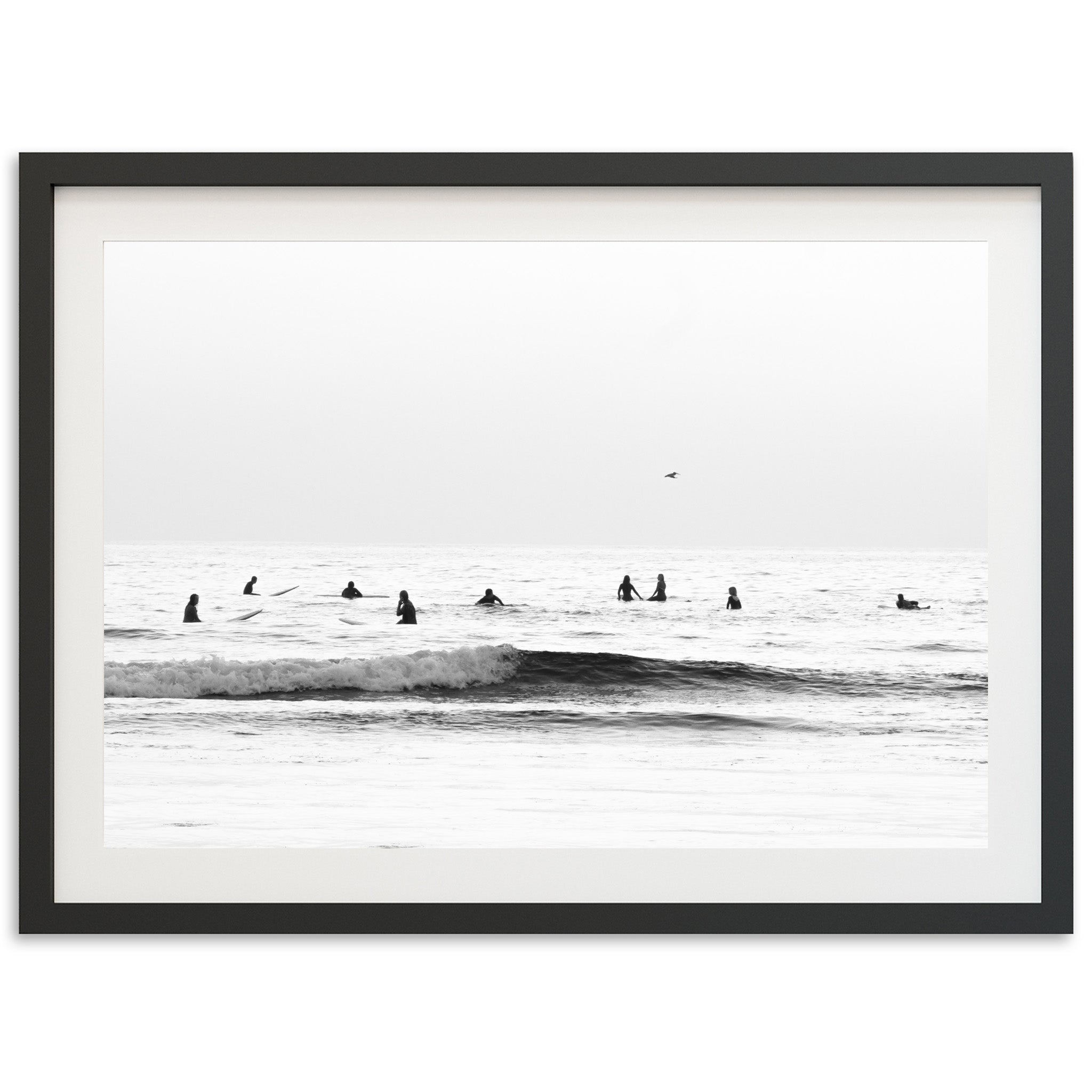 a black and white photo of surfers in the ocean