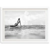 a woman laying on a surfboard in the ocean