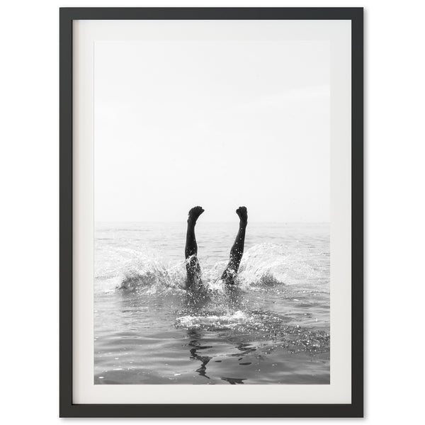 a black and white photo of two people in the water