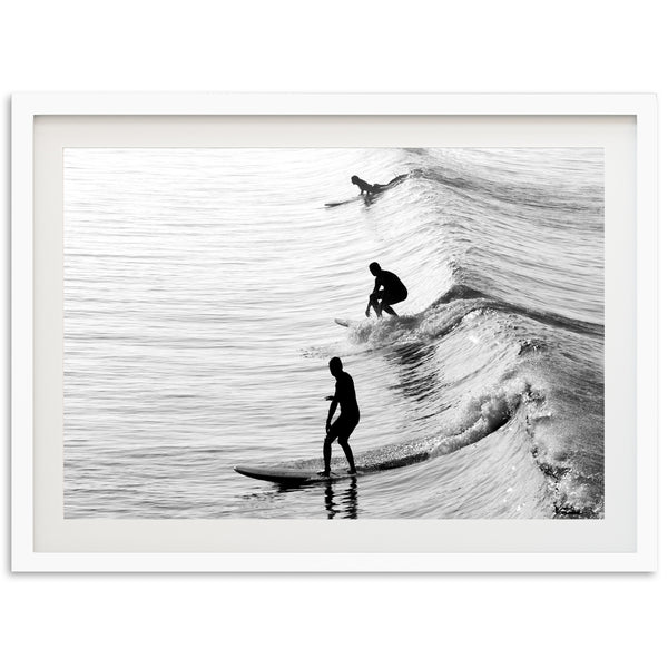 a black and white photo of two people surfing