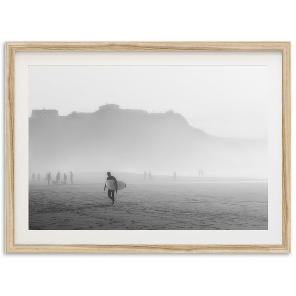 a black and white photo of a person carrying a surfboard