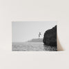 a black and white photo of a person jumping off a cliff into the ocean